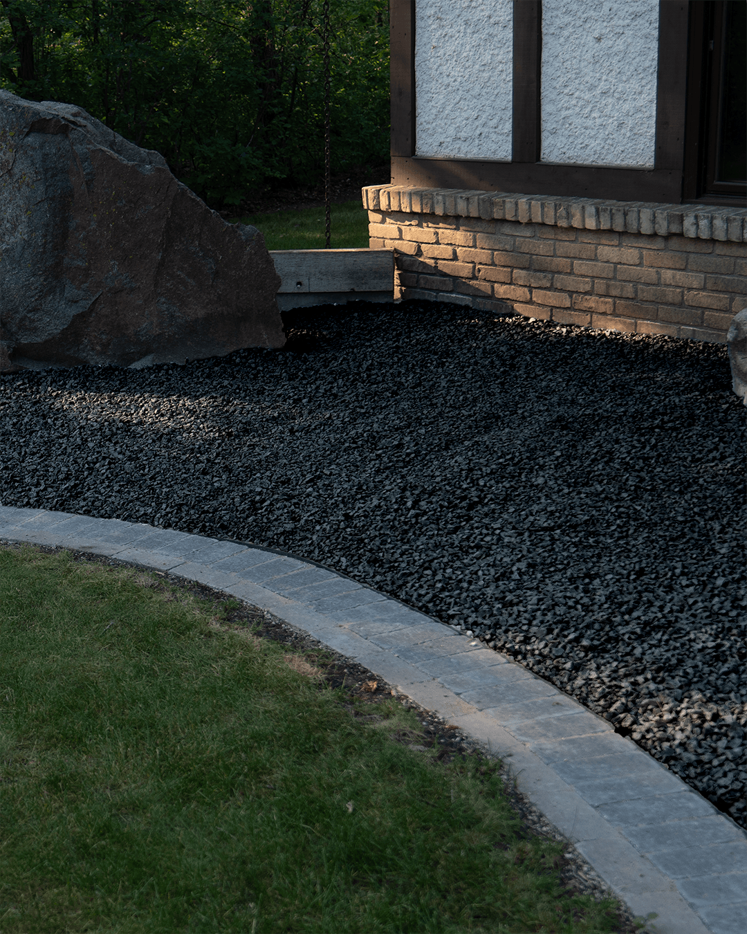 Black Granite as a foundation bed outside a home with concrete curbing